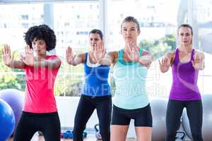 Women in fitness studio with arms stretched forward