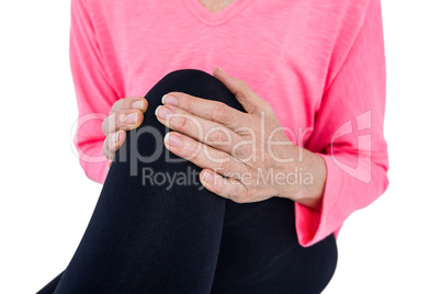 Mid section of woman suffering from knee pain