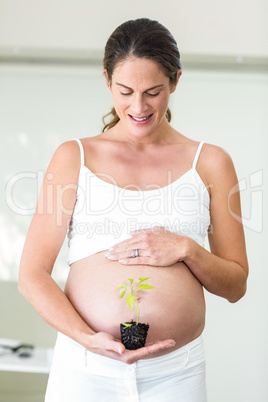 Happy woman with new plant in palm