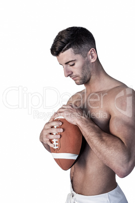 Shirtless rugby player holding the ball