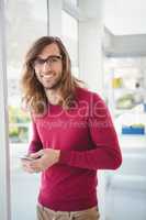Portrait of happy hipster using mobile phone