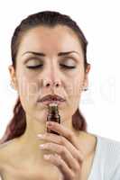 Close-up of woman smelling bottle of medicine