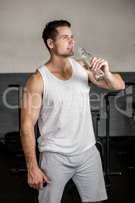 Muscular man holding water bottle