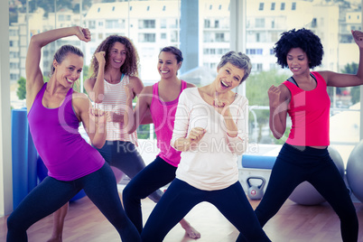 Portrait of happy women exercising with clasped hands