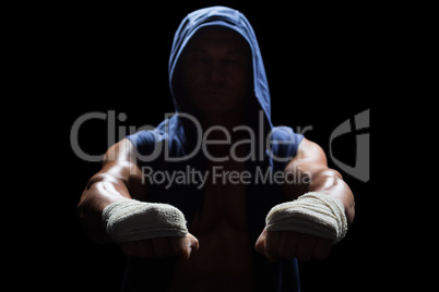 Muscular man in hood with bandage on hand