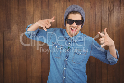 Happy hipster showing rock and roll hand sign