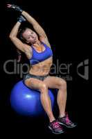 Portrait of woman stretching while sitting on exercise ball
