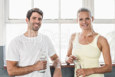 Couple holding bottle of water posing