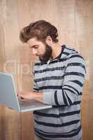 Hipster using laptop while standing