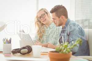 Smiling woman wearing eyeglasses talking with man