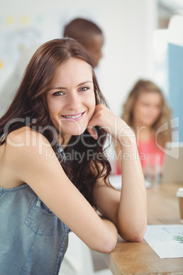 Portrait of smiling woman sitting at desk Portrait of smiling woman sitting at desk