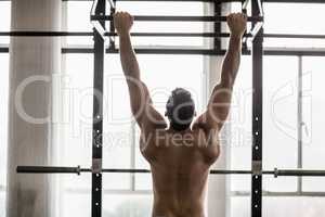 Muscular man lifting himself up and down