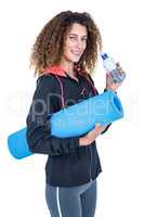 Young woman holding water bottle and exercise mat