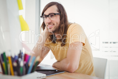 Hipster wearing eye glasses working at computer desk