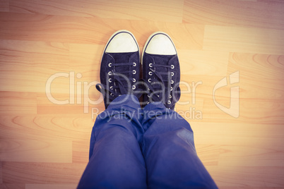 Low section of man standing on hardwood floor