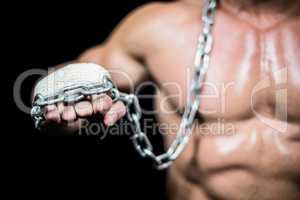Midsection of bodybuilder fist with chain