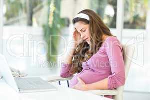 Unhappy pregnant woman with headache