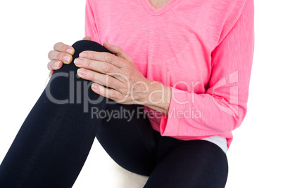 Mid section of mature woman massaging knee