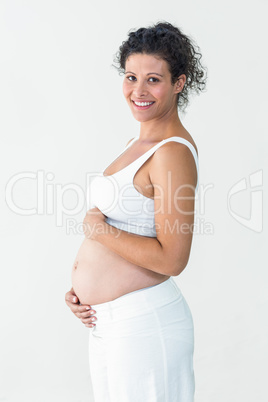 Happy pregnant woman touching tummy