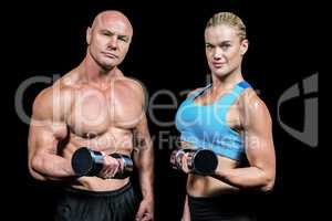 Portrait of muscular man and woman lifting dumbbells