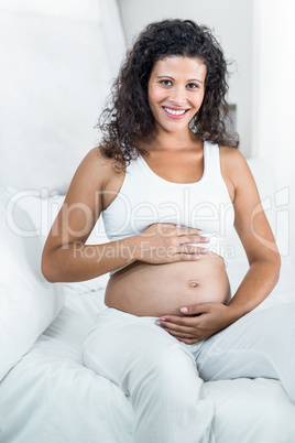 Portrait of pregnant woman touching tummy