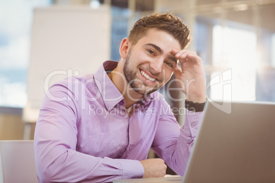 Smiling businessman working with laptop