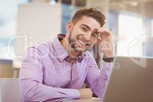 Smiling businessman working with laptop