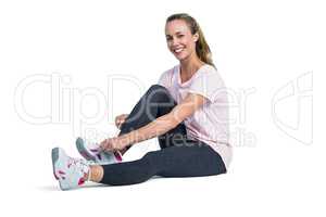 Portrait of sporty woman smiling while tying shoelace