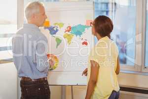 Business people discussing about world map on whiteboard