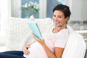 Portrait of pregnant woman reading book