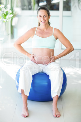 Portrait of happy woman sitting on ball