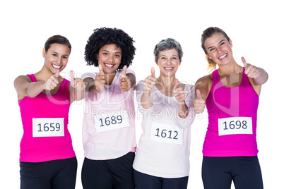 Portrait of cheerful female athletes with thumbs up