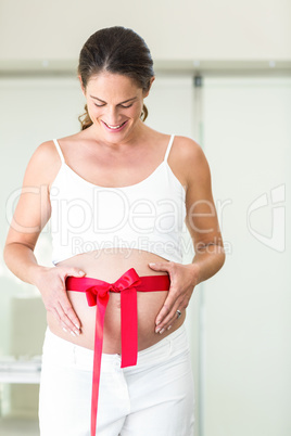 Happy woman looking down on red ribbon