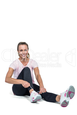 Portrait of woman smiling while tying shoelace