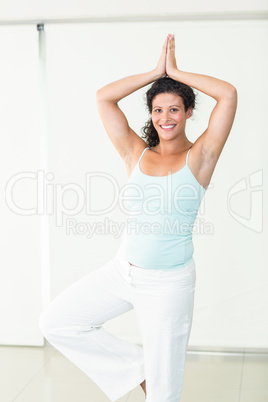 Happy pregnant woman in tree position