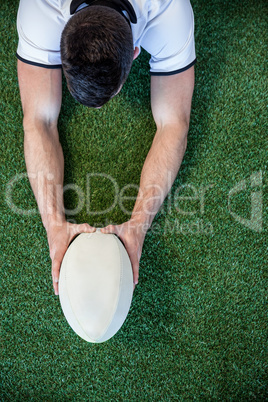High angle view of man holding rugby ball with both hands