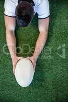 High angle view of man holding rugby ball with both hands