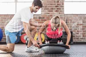 Trainer motivating client doing push ups