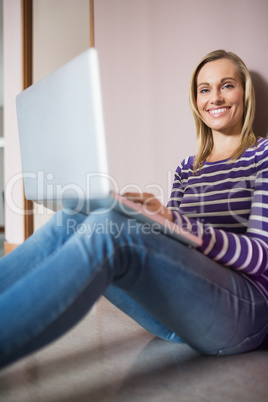 Portrait of happy female student using laptop