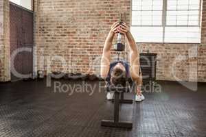 Man lifting dumbbell lying on bench