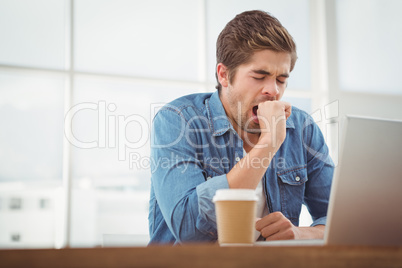 Tired businessman sitting at desk