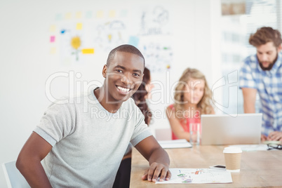 Portrait of smiling man while sitting at desk