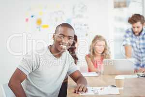 Portrait of smiling man while sitting at desk