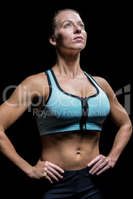 Thoughtful athlete looking up with hand on hip