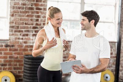 Woman discussing her performance on clipboard with trainer