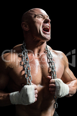 Aggressive muscular man holding chain