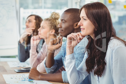 Thoughtful business people with hand on chin