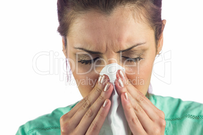 Close-up of woman suffering from cold with tissue on mouth