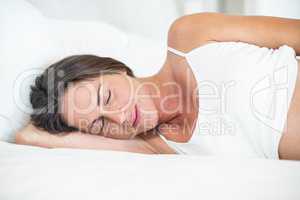 Happy woman sleeping on bed