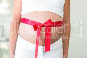 Midsection of woman with red ribbon